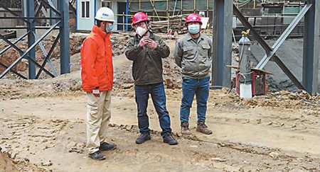 李峰（中）在仙福钢铁产能置换技术升级改造二期项目建设现场与技术工人讨论技改细节。